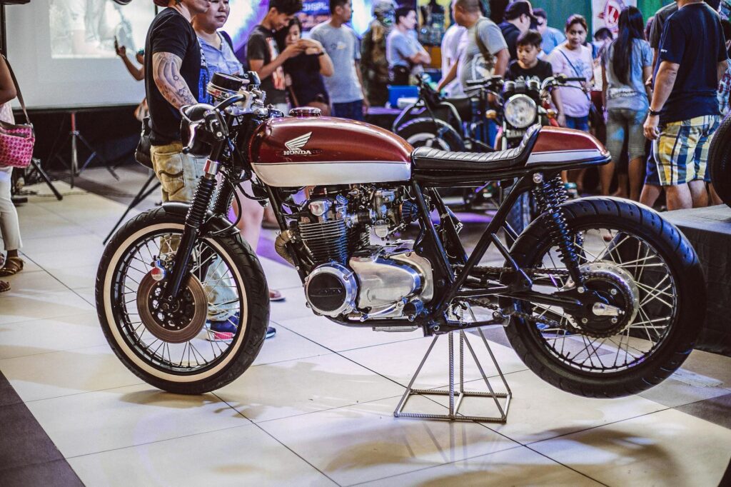 Motocicleta Brown Honda Exibida Dentro Do Prédio Com As Pessoas