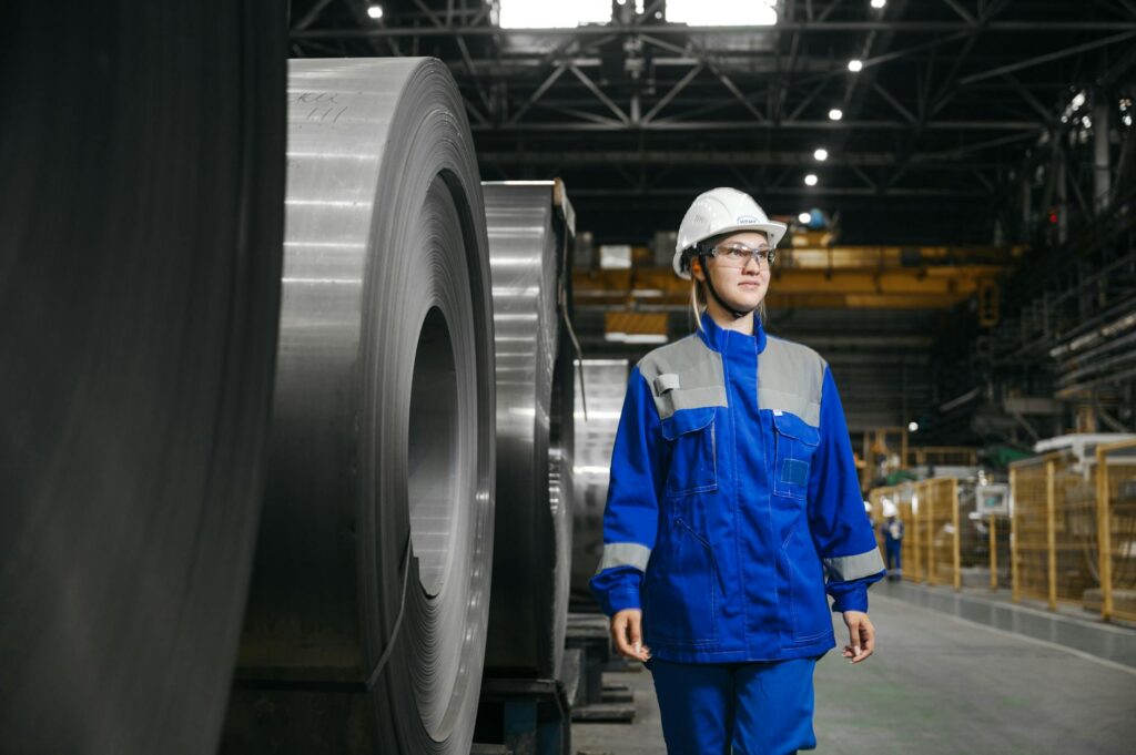 Trabalhadora industrial usando equipamento de proteção em uma fábrica de aço.